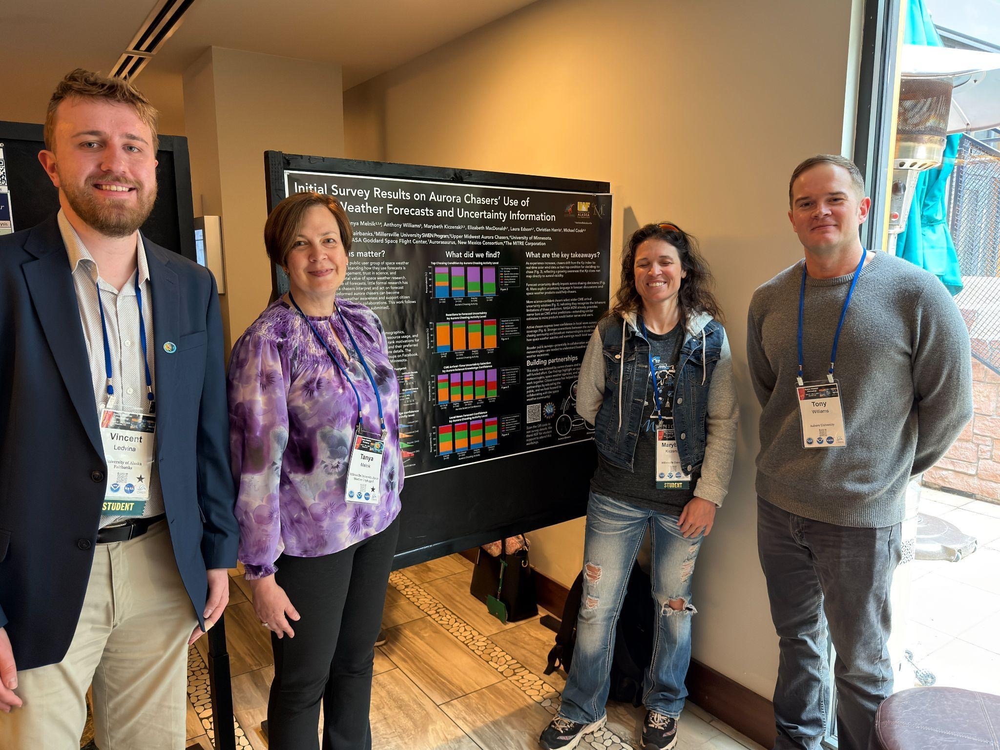Four conference participants stand beside a research poster displaying survey results related to aurora forecasting and citizen science.