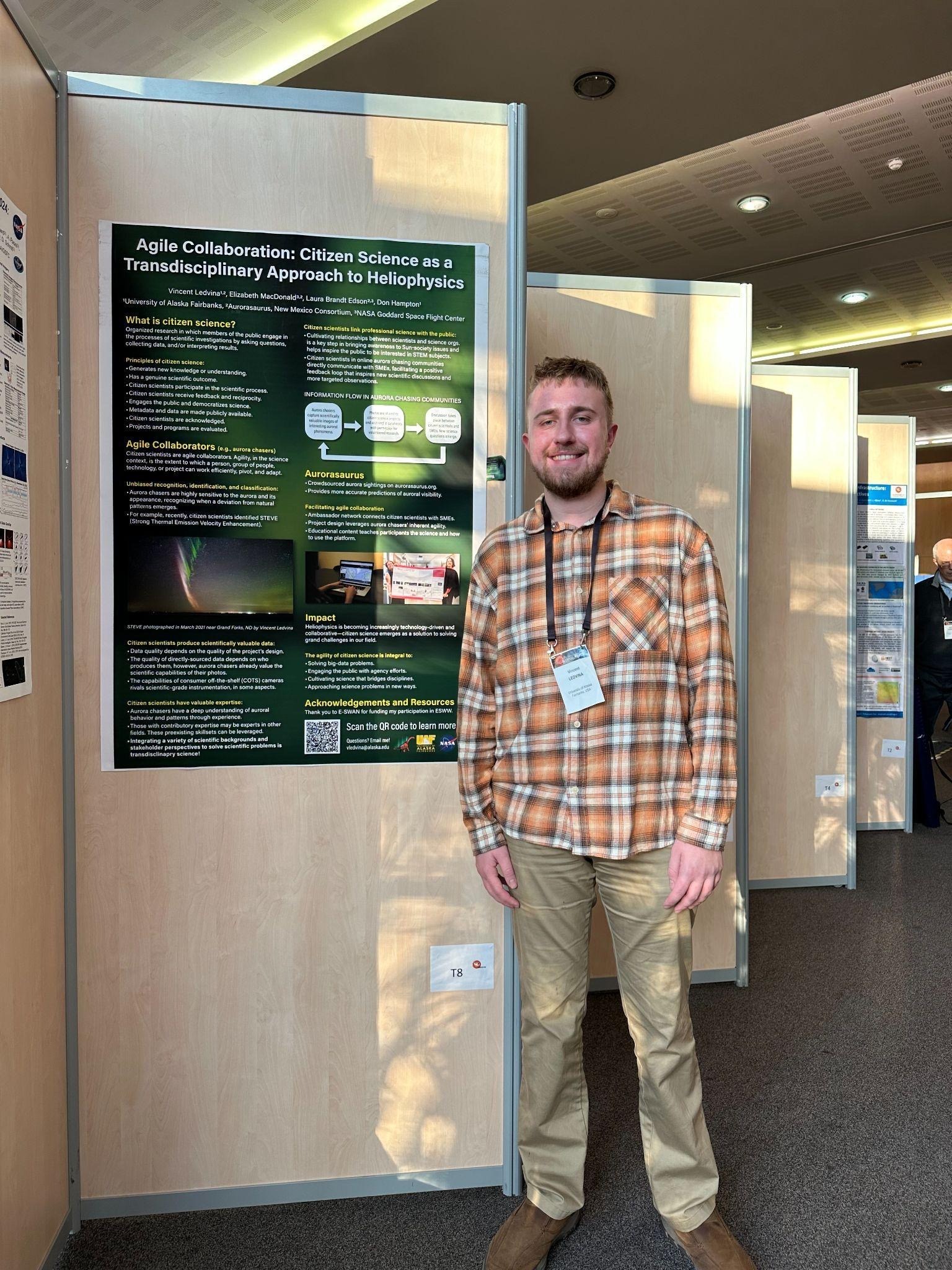 Vincent stands at a conference beside a poster presenting his work on citizen science in heliophysics