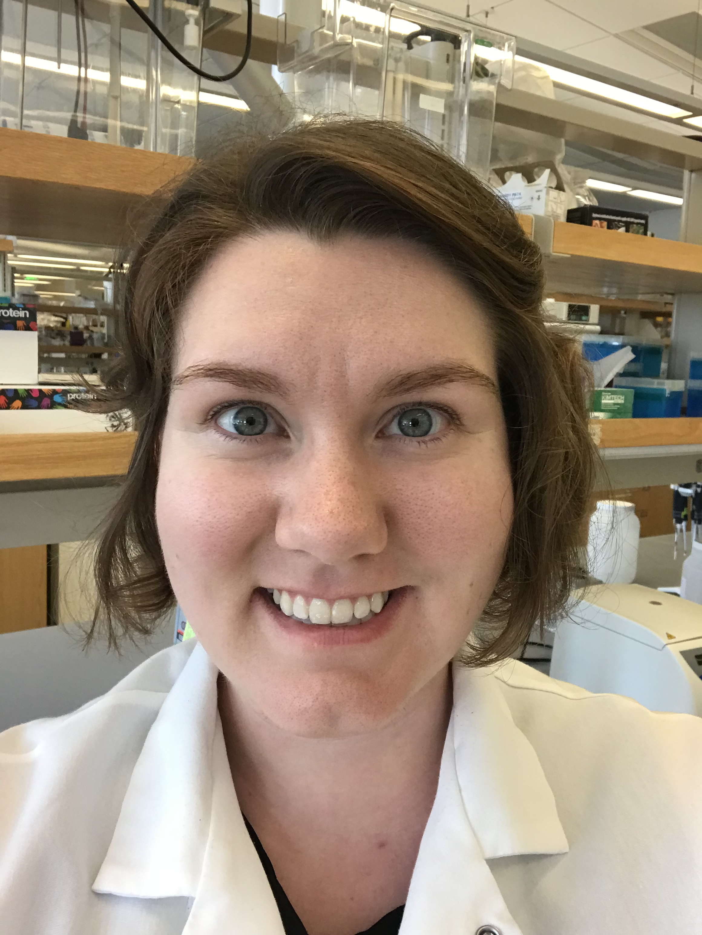 Photograph of Brooke Long-Fox with laboratory bench and shelves in background